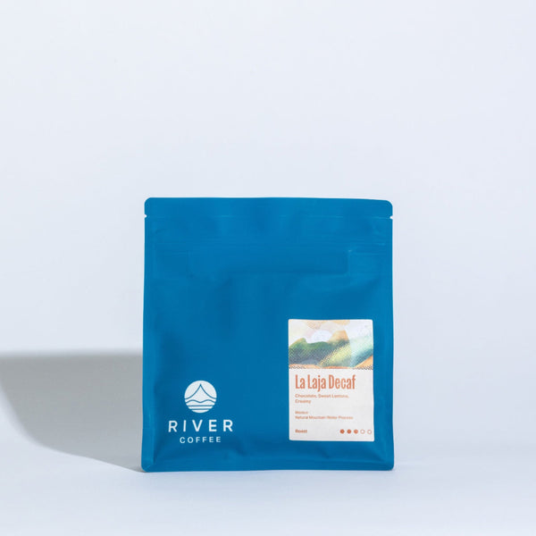 Blue coffee package with 'River Coffee' branding on a light gray background